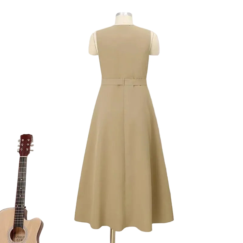 Beige dress on a mannequin against a white paneled wall with a guitar and small table with flowers in the foreground.