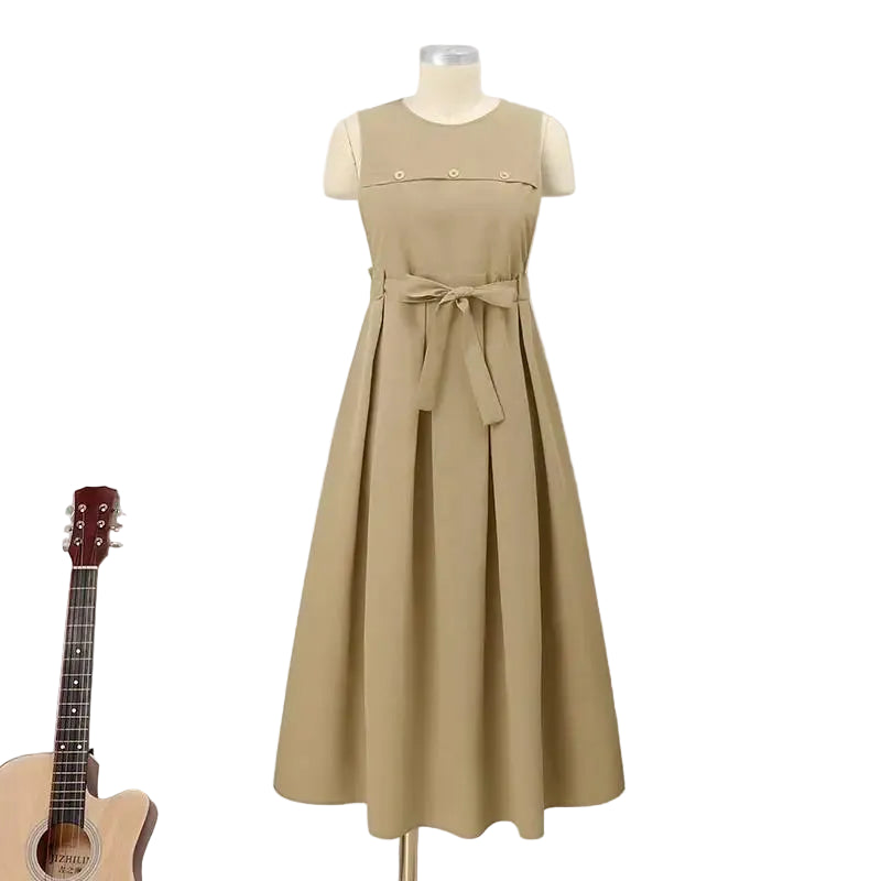 Beige dress on a mannequin against a white paneled wall with a guitar and small table with flowers in the background.